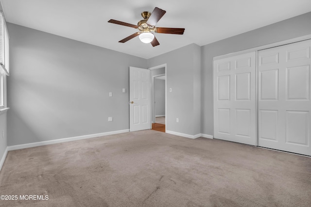 unfurnished bedroom with a closet, baseboards, carpet floors, and ceiling fan