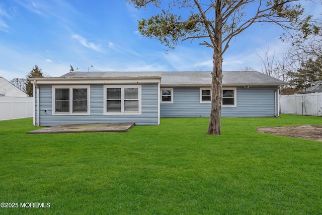 back of house featuring a lawn and fence