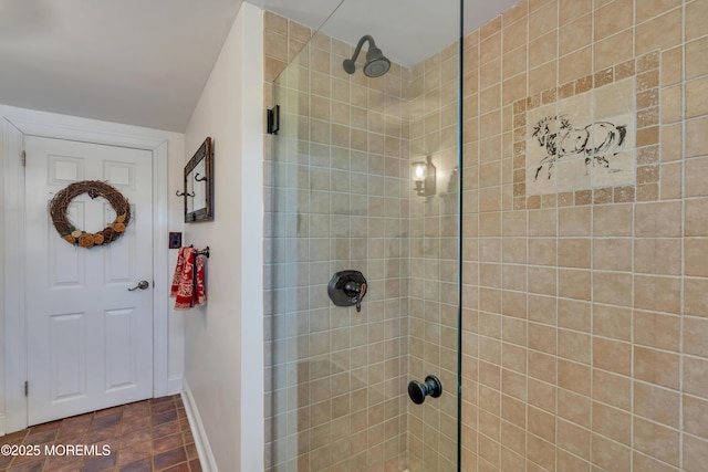 full bath with baseboards and tiled shower