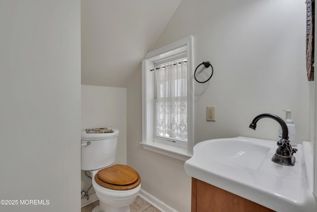 bathroom featuring baseboards, lofted ceiling, toilet, and vanity