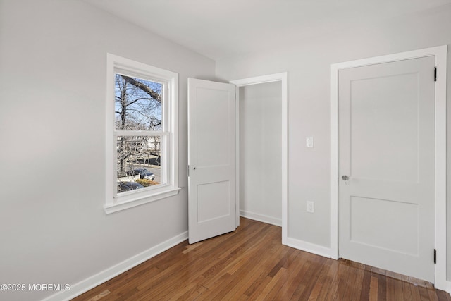 unfurnished bedroom featuring baseboards and wood-type flooring