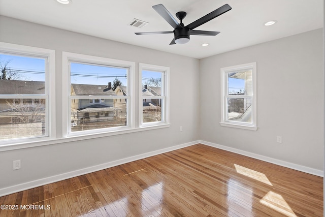 unfurnished room featuring a ceiling fan, visible vents, baseboards, recessed lighting, and wood-type flooring