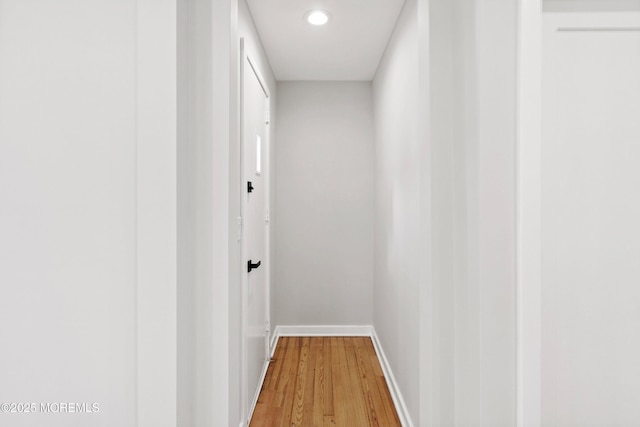 corridor with baseboards and wood finished floors