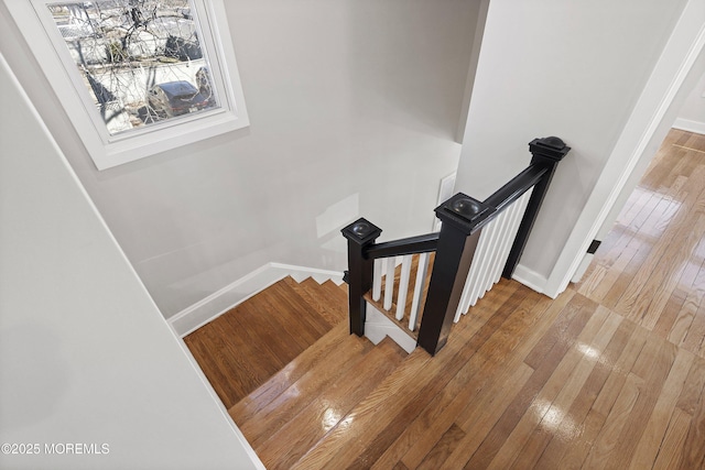 staircase featuring baseboards and hardwood / wood-style flooring