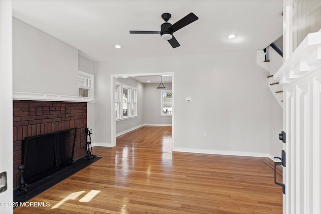 living area featuring a ceiling fan, recessed lighting, light wood finished floors, baseboards, and a brick fireplace