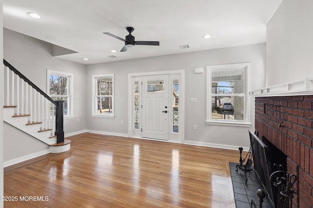 entrance foyer featuring stairway, baseboards, visible vents, and light wood finished floors