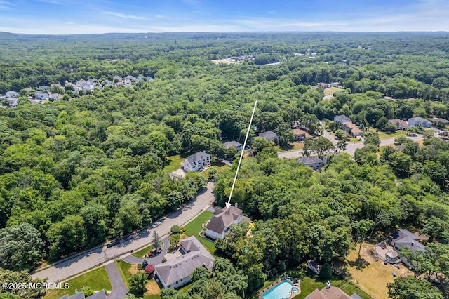 drone / aerial view featuring a residential view and a forest view