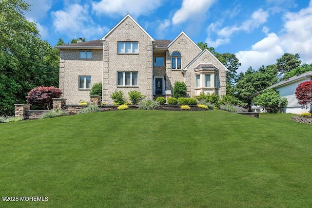 view of front of property featuring brick siding and a front lawn