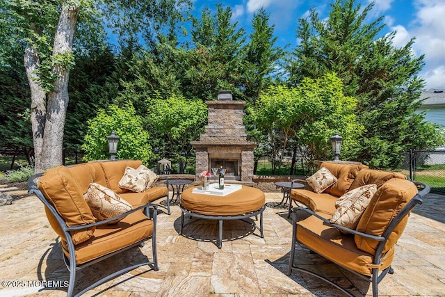 view of patio featuring an outdoor living space with a fireplace and fence