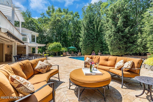 view of patio featuring an outdoor living space, an outdoor pool, and a balcony