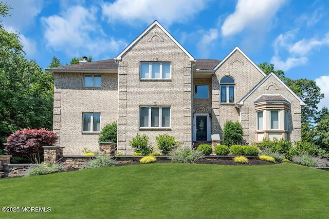 traditional home with a front lawn and brick siding