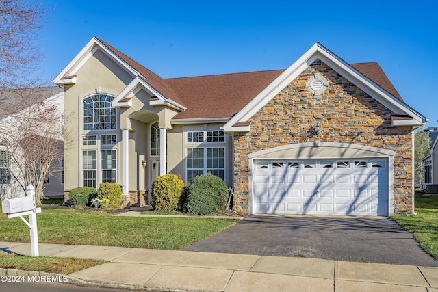 traditional-style house featuring stone siding, driveway, and an attached garage