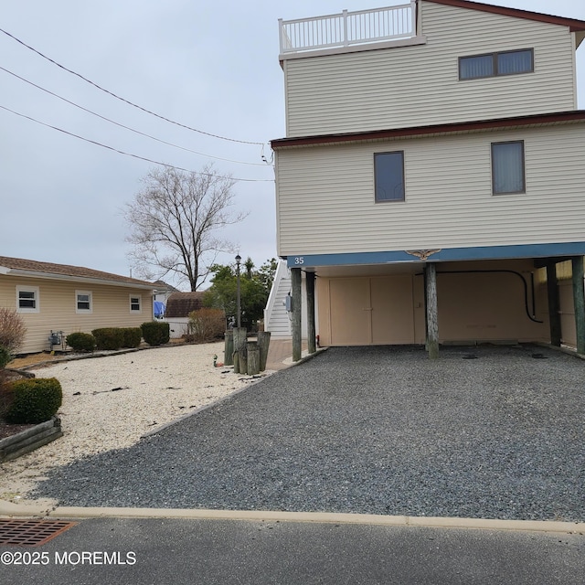 view of home's exterior with a carport and gravel driveway