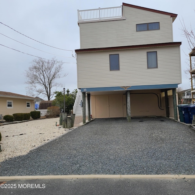 raised beach house with a carport and driveway