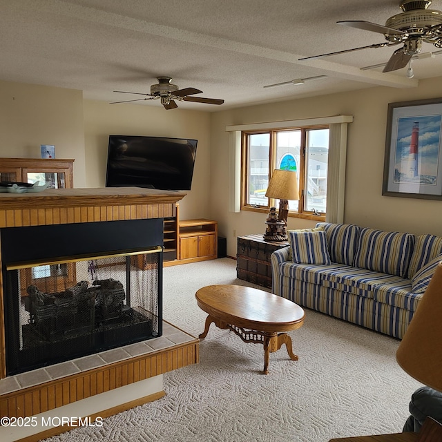 living area with a multi sided fireplace, carpet, a ceiling fan, and a textured ceiling