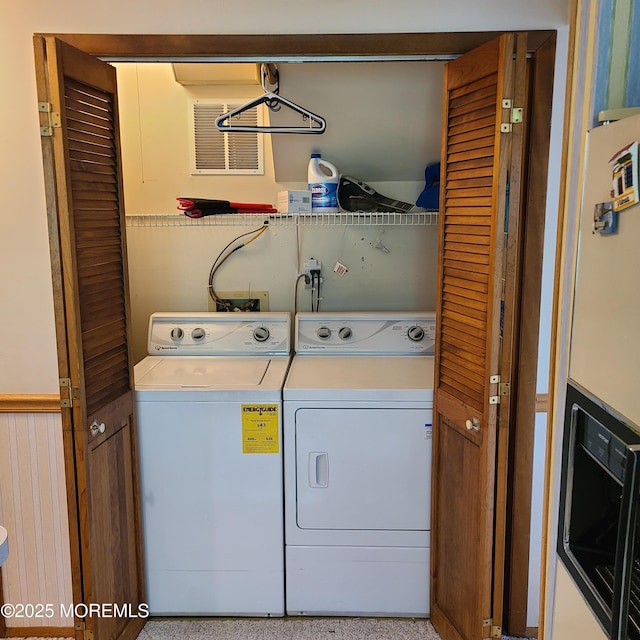 washroom featuring washer and dryer, laundry area, and a wainscoted wall