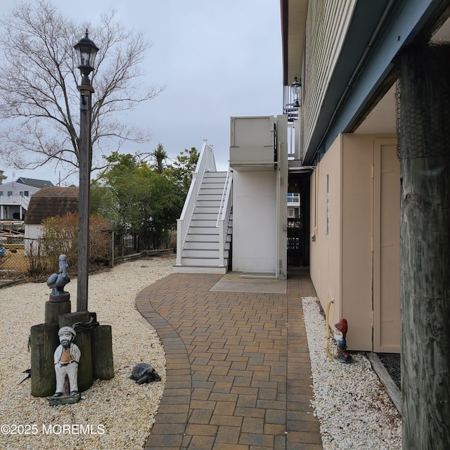 view of patio with stairs and fence