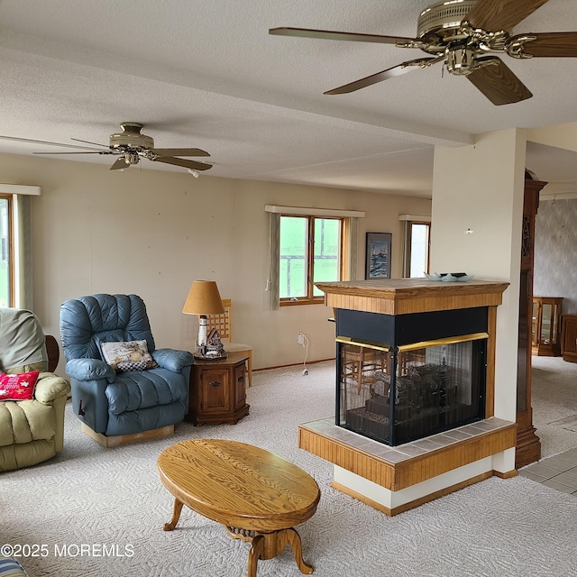 living room featuring a multi sided fireplace, a textured ceiling, carpet, and a ceiling fan