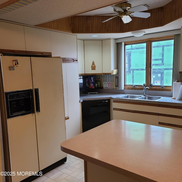 kitchen with a ceiling fan, a sink, light countertops, black dishwasher, and white refrigerator with ice dispenser