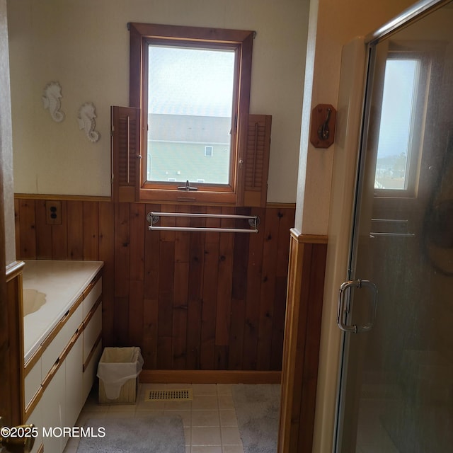 full bathroom featuring vanity, wooden walls, a shower stall, and wainscoting