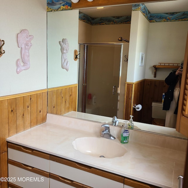 full bathroom with a wainscoted wall, a stall shower, vanity, and wood walls