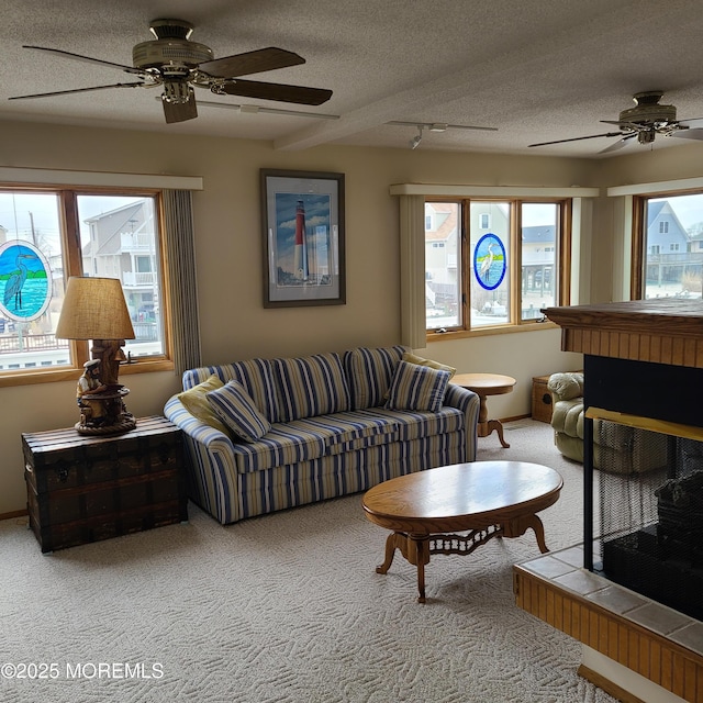 living area with light colored carpet, a textured ceiling, and ceiling fan