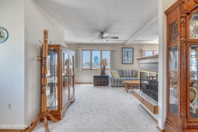 35 W Mohawk Dr, Little Egg Harbor, NJ 08087 - carpeted living area with a textured ceiling, ceiling fan, a fireplace with raised hearth, and baseboards