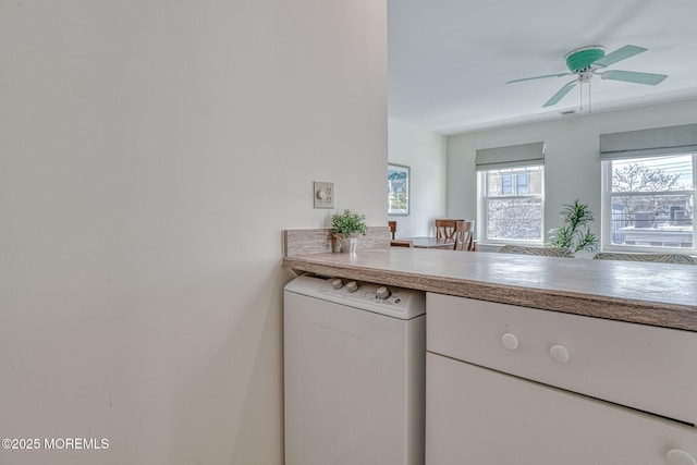 kitchen featuring washer / dryer and ceiling fan