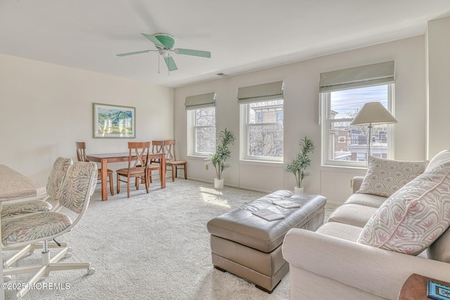 living area featuring a ceiling fan, visible vents, carpet, and baseboards