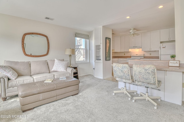 living room with visible vents, baseboards, ceiling fan, light colored carpet, and recessed lighting