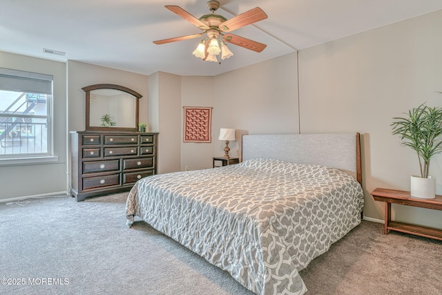 carpeted bedroom featuring baseboards, visible vents, and ceiling fan