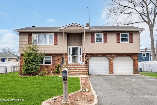 split foyer home with brick siding, a garage, a front yard, and fence