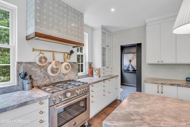 kitchen with tasteful backsplash, dark wood finished floors, light countertops, high end stainless steel range oven, and white cabinetry