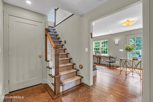 staircase featuring parquet floors, recessed lighting, and baseboards