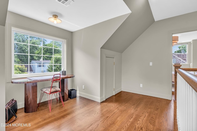 office space featuring visible vents, baseboards, wood finished floors, and vaulted ceiling