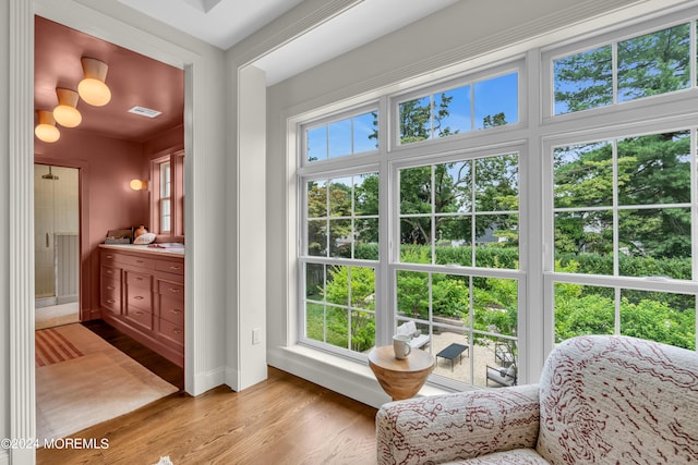 sitting room with a wealth of natural light, baseboards, visible vents, and light wood finished floors