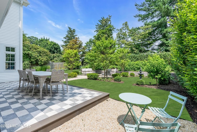 view of yard featuring outdoor dining area, fence, and a patio area