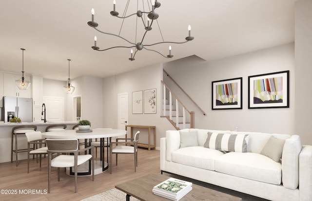 living room featuring a chandelier, stairs, and light wood-style floors