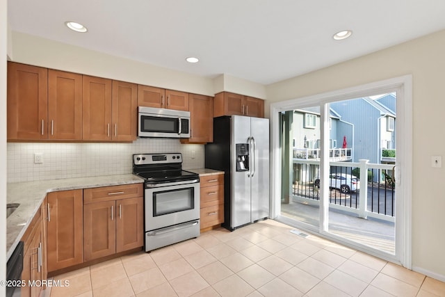 5 Island View Way Unit 3, Sea Bright, NJ 07760 - kitchen featuring appliances with stainless steel finishes, brown cabinetry, backsplash, light stone counters, and recessed lighting