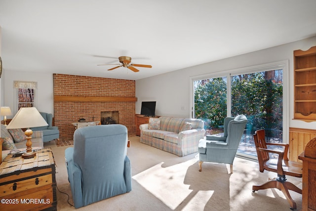 living area featuring a brick fireplace, carpet, and ceiling fan