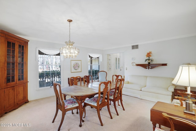 dining room featuring a chandelier, visible vents, light colored carpet, and crown molding