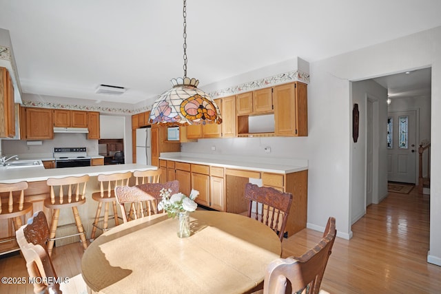 dining space featuring visible vents, light wood-type flooring, and baseboards