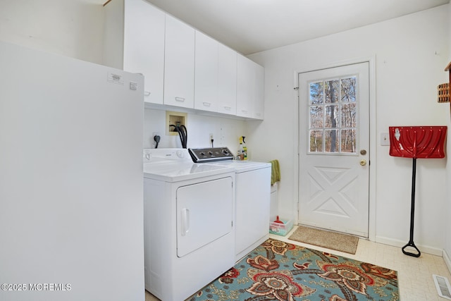 washroom featuring cabinet space, light floors, and washing machine and dryer