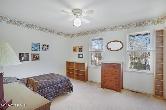 bedroom featuring a ceiling fan, baseboards, visible vents, and light carpet