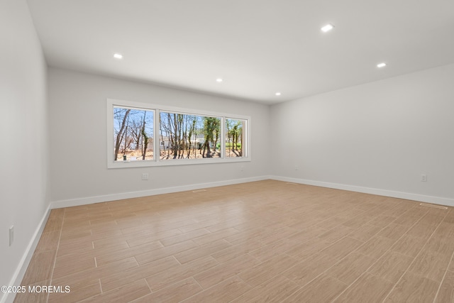 empty room with recessed lighting, baseboards, and light wood-style flooring