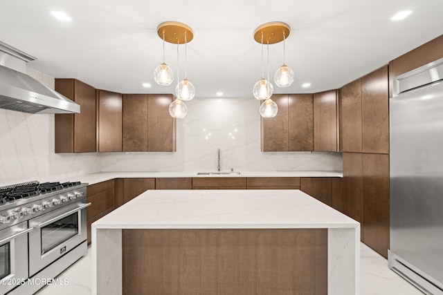 kitchen featuring a sink, wall chimney range hood, high quality appliances, modern cabinets, and marble finish floor