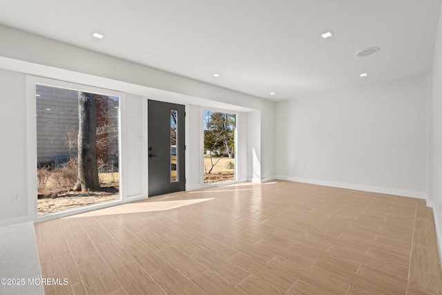 spare room with light wood-style flooring, recessed lighting, and baseboards