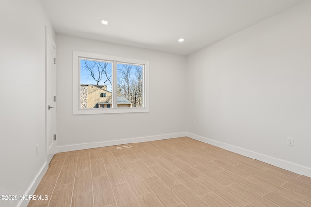 empty room with recessed lighting, baseboards, and light wood-style floors