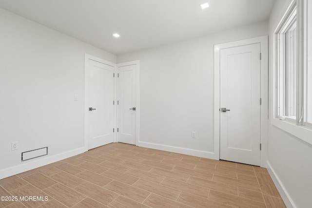 empty room featuring recessed lighting, baseboards, and wood finish floors