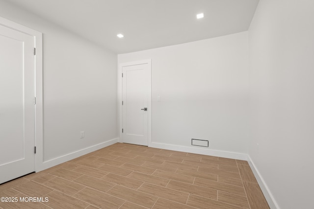 empty room with recessed lighting, baseboards, and wood tiled floor